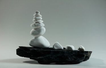 white smooth stones balanced over one black flat stone  - 640817314