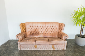 Empty old brown leather sofa seat on cement floor,black classic loft interior in living room,cafe or restaurant interior design concept.