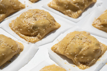 Traditional cypriot easter cheese pastries called flaounes in a table ready to be cooked in the clay oven.
