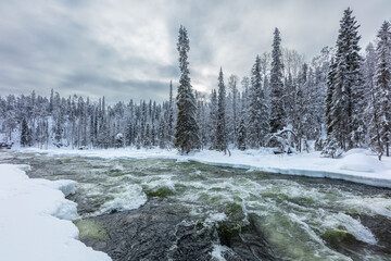 Winter in Finland; landscape in Oulanka National Park with wild river and snow covered boreal...