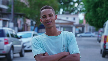 Friendly Young Brazilian Man crossing arms standing in urban street, Authentic Portrait of Real Life People