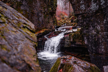 waterfall in the middle of the forest in the colourful autumn season