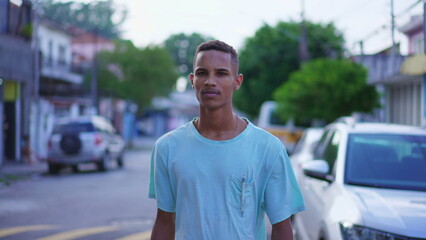 One pensive black Brazilian young man walking outside in street with contemplative gaze. Thoughtful...
