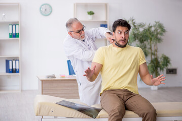 Obraz premium Young male patient visiting old male doctor