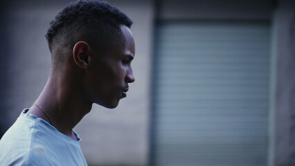 One pensive black man walking forward in street in deep mental reflection and worried emotion....