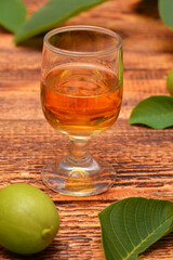 shot glass with tincture on wooden background close-up