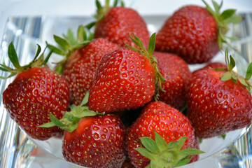 A handful of delicious strawberries on a decorative glass plate.