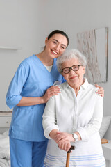 Young caregiver with senior woman in bedroom - obrazy, fototapety, plakaty