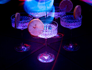 A glass of wine reflected in mirrors and illuminated by colored light