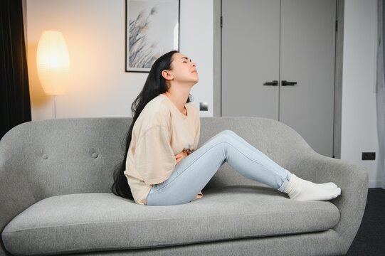 Menstrual pain, woman with stomachache suffering from pms at home, endometriosis, cystitis and other diseases of the urinary system.