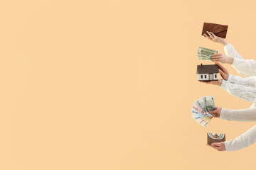 Women with money, wallets and house model on beige background