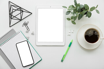 Stationery with tablet, phone and cup of coffee on white background