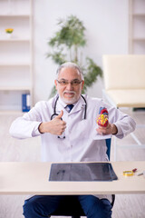 Old male doctor cardiologist working in the clinic