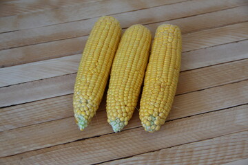 Cobs of fresh young corn on wooden background