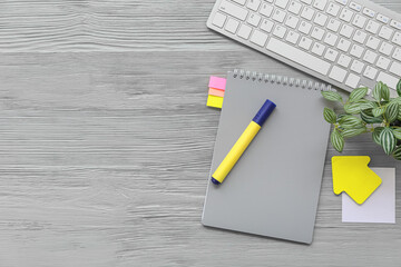 Keyboard with houseplant and different stationery on grey wooden background