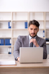 Fototapeta premium Young male employee working in the office