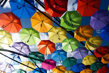 Fototapeta na wymiar Colorful umbrella pattern. Vivid color street decoration. Holiday summer vibe background. Different colors umbrellas texture. Rainbow background.