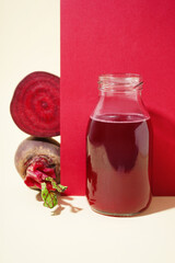 Bottle of healthy beet juice on colorful background