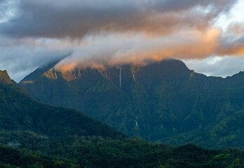 Mountains of the Na Pali mountain range in the distance above Hanalei Bay in Kauai. Sun just...