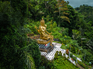 Aerial Glimpse of Bali's Jungle and Brahma God Statue. Discover the Rich Hinduism Heritage of...