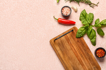 Composition with wooden kitchen board and fresh spices on color background