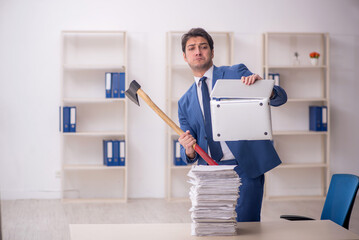 Young male employee unhappy with excessive work in the office
