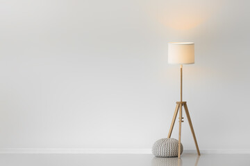 Glowing lamp with pouf in light room