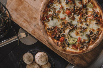 pizza on a table.A photo of pizza with styling - stock photo - pizza - pizza on the table and mushrooms next to it - close-up view