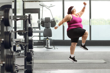 Fototapeta na wymiar Young overweight woman exercising in a gym