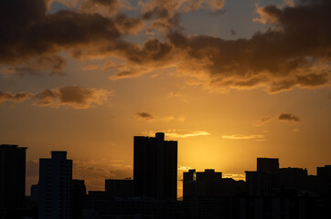 Fototapeta na wymiar Orange Sunset Above a Dark Cityscape.