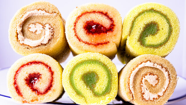 background image, cake  Rolls, three flavors, colorful, appetizing, on a white plate.