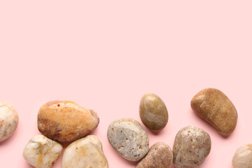 Many pebble stones on pink background