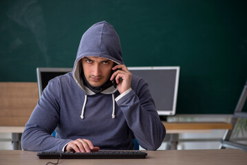 Young male hacker sitting in the classroom
