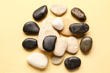 Fototapeta na wymiar Many pebble stones on yellow background