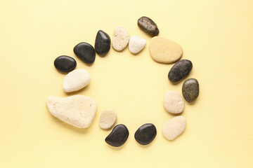 Frame made of pebble stones on yellow background