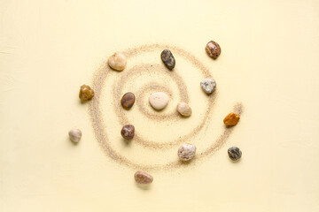 Many pebble stones and sand on yellow background