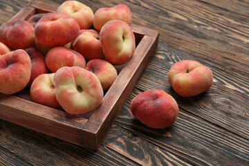 Box with sweet fig peaches on wooden background
