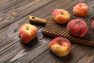 Board with sweet fig peaches on wooden background