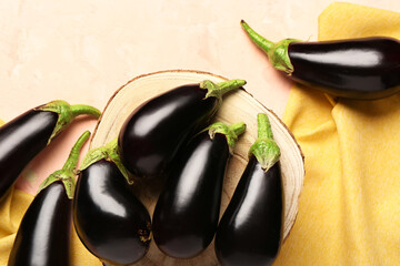 Wooden stand with fresh eggplant on light background