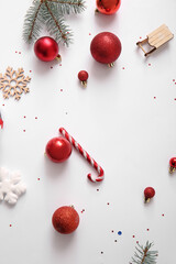 Christmas tree branches with balls, snowflakes and candy cane on white background
