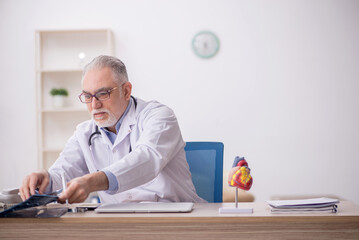 Old male doctor radiologist working at the hospital