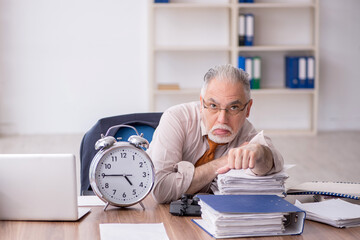 Old male employee in time management concept