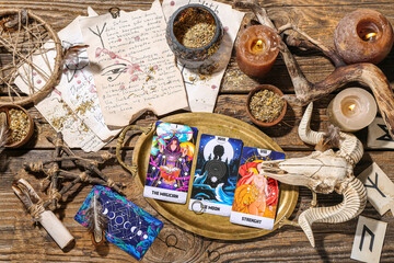 Witch's magic attributes with tarot cards on wooden table