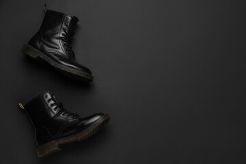 Stylish leather boots on black background