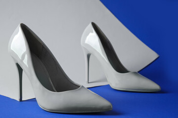 Fototapeta na wymiar Stylish grey high heels on colorful background