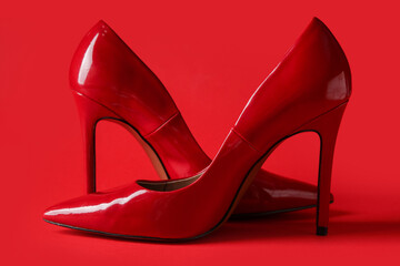 Stylish red high heels on color background