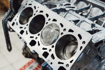 Overhaul of the motor for the car. Parts of an internal combustion engine. Cylinder block with pistons and valves.