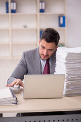 Young male employee unhappy with excessive work in the office