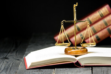 Legal Law and Justice concept - Open law book with a wooden judges gavel on table in a courtroom or law enforcement office. Copy space for text. - 640909581