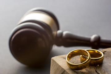 Divorce and separation concept. Two golden wedding rings, judge gavel.